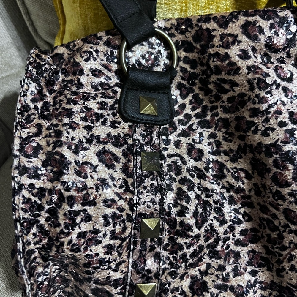 Non- leather handbag . Made of cloth and sequins. Leopard print. Cute and light.